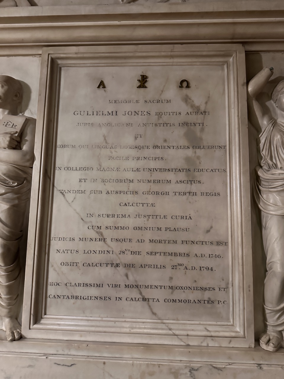 Central Latin inscription of the Sir William Jones memorial, flanked by sculpted figures and surmounted by Christian symbols.
