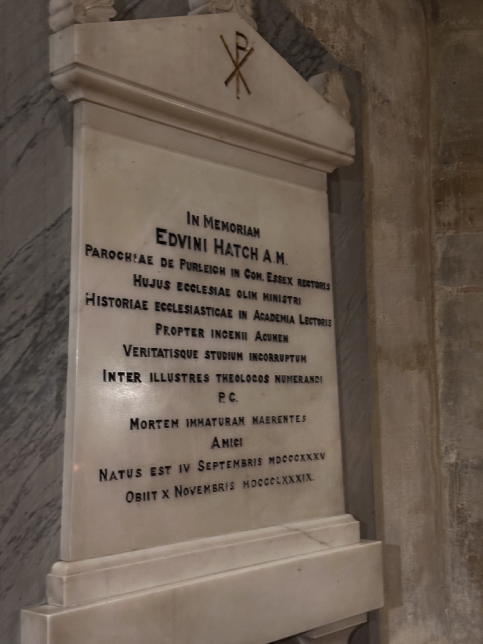Latin memorial to Edwin Hatch, beneath a Christogram, recording his ministry, university readership and devotion to truth.